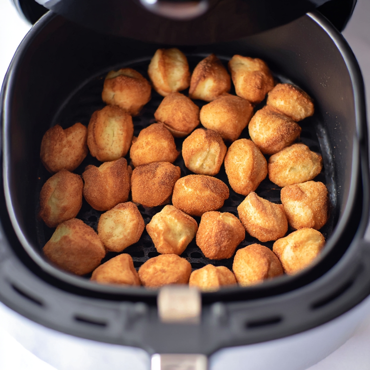 Golden, crispy churro bites in the air fryer, coated in cinnamon sugar, perfect for a quick and sweet dessert recipe