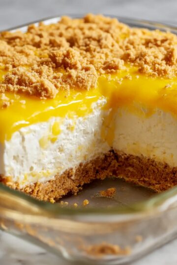 Lemon cream cheese dump cake with bright lemon topping and crumb crust in glass baking dish