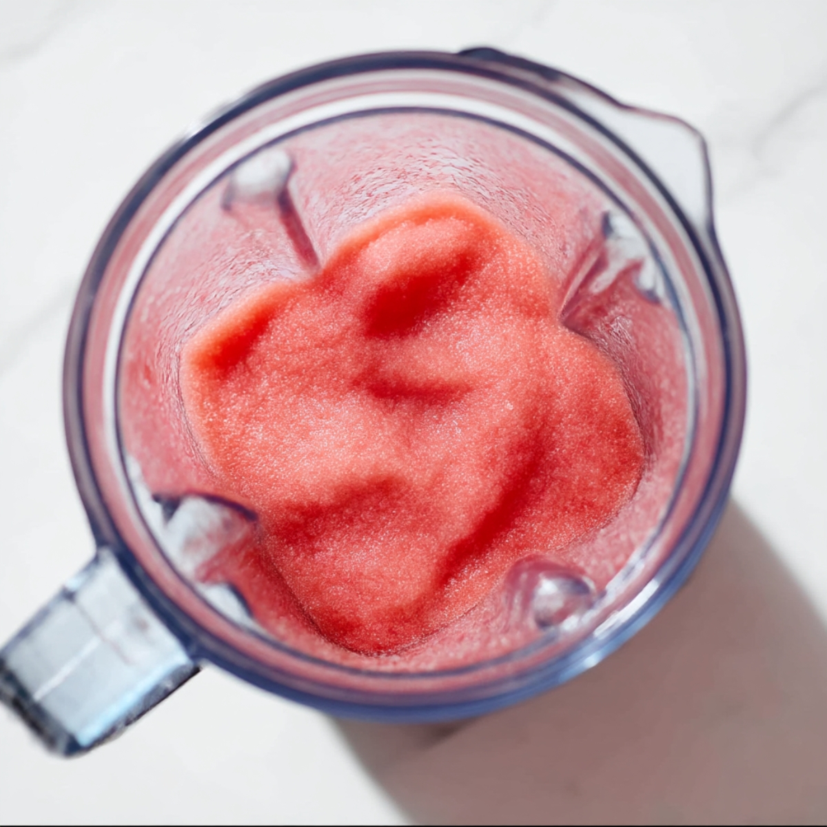 A vibrant and refreshing watermelon slushie blend, perfect for hot summer days, showing a smooth texture in a blender.