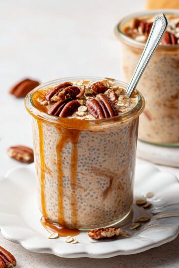 Creamy brown sugar overnight oats made with chia seeds, topped with crunchy pecans and a rich caramel drizzle, served in a glass jar for a healthy breakfast recipe.