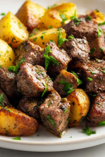 Tender beef bites perfectly seared and served with golden roasted potatoes, garnished with fresh parsley. A quick and delicious dinner idea!