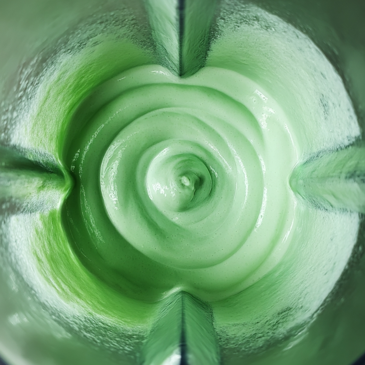 A vibrant green Shamrock Shake in a blender, showcasing a smooth, creamy texture ready for serving.